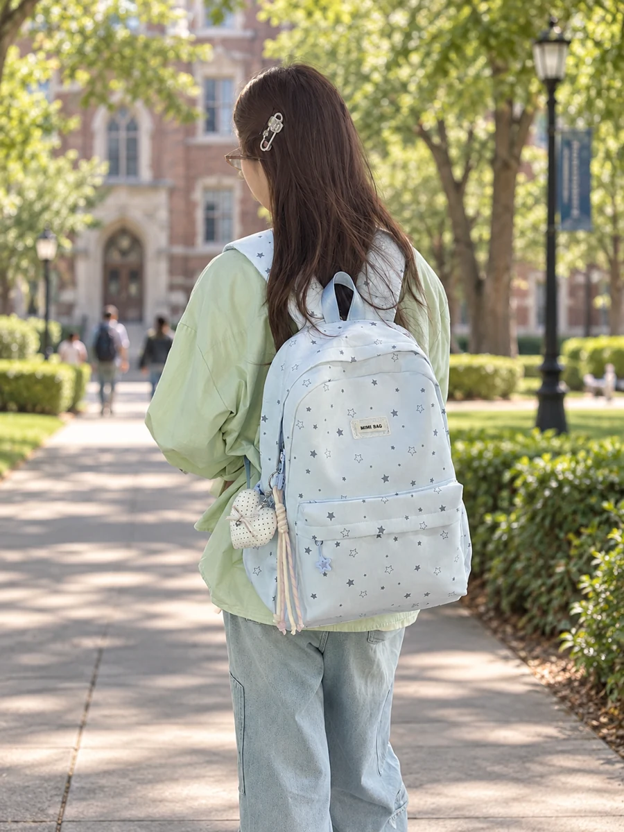 Light blue star print backpack on a leafy campus